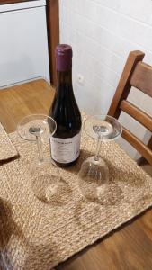 una botella de vino sentada en una mesa con dos copas de vino en El Tinao de la Hiruela (Entremelojos) en La Hiruela