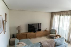 uma sala de estar com um sofá azul e uma TV de tela plana em Villa Fidel Murcia em Múrcia