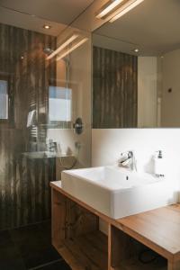 a bathroom with a white sink and a mirror at Garni Appartements Arnika in Solda