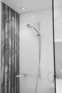 La salle de bains est pourvue d'une douche avec rideau de douche. dans l'établissement Garni Appartements Arnika, à Sulden