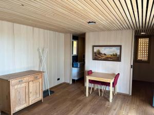 Habitación con mesa de madera y escritorio con silla. en Tiny House Brunn am Gebirge en Brunn am Gebirge