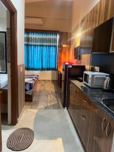 a small kitchen with a sink and a microwave at Luxury apartment near expo in Greater Noida