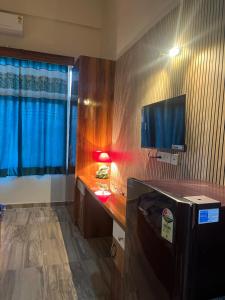 a room with a desk with a tv and a window at Luxury apartment near expo in Greater Noida