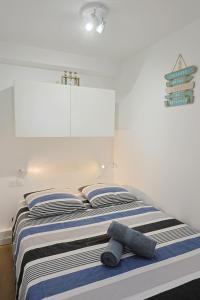 ein Bett mit blau-weißer gestreifter Bettwäsche und zwei Kissen in der Unterkunft Studio tout équipé vue Port in La Grande-Motte