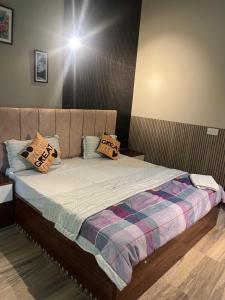 a bed with pillows on it in a room at Luxury apartment near expo in Greater Noida