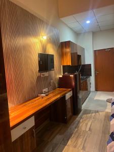 a room with a wooden desk with a tv on the wall at Luxury apartment near expo in Greater Noida