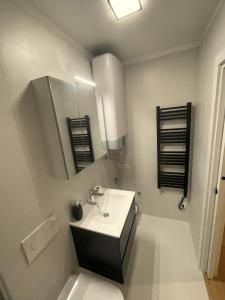 ein weißes Badezimmer mit einem Waschbecken und einem Spiegel in der Unterkunft LUNAR apartments in Izola