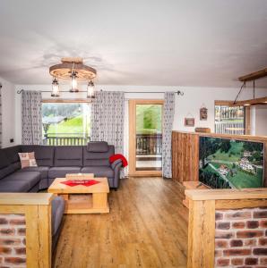 ein Wohnzimmer mit einem Sofa und einem TV in der Unterkunft Alpen Chalet Wohnung "Martha" in Zellberg