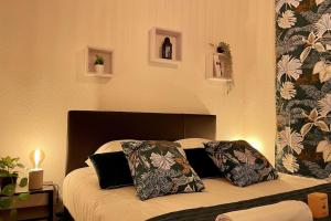 una camera da letto con un letto con due cuscini sopra di Rouen Seine - Magnifique appart - Parking gratuit a Rouen