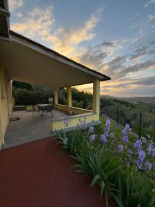 カルミニャーノにあるAgriturismo Sotto la Roccaの紫の花のパティオ付きの家