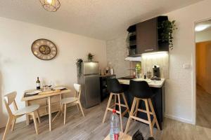 una cucina con tavolo, sedie e frigorifero di Rouen Seine - Magnifique appart - Parking gratuit a Rouen Altre 23 foto