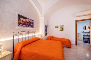 two beds in a bedroom with orange sheets at Casa Hermes in Atrani