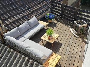 a couch on a wooden deck with a table and flowers at Art & Living Apartment in Schoneck