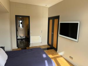 een slaapkamer met een bed en een flatscreen-tv bij Fabulous apartment in heart of Paris in Parijs