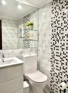 La salle de bains est pourvue de toilettes blanches et d'un lavabo. dans l'établissement Vivienda con Parking incluido - Zona Van Dyck, à Salamanque