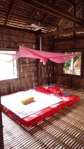 1 cama grande roja y blanca en una habitación en OBT - The Coconut Bungalow 