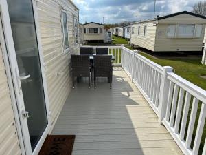 a deck with a table and chairs on a house at Tracey and Brian's Caravan in Rhyl
