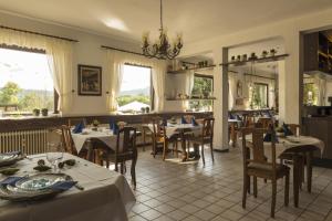 a restaurant with tables and chairs and a chandelier at Hotel Restaurant Häsfeld in Überherrn