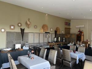 a dining room with tables and chairs and a restaurant at Hôtel Le Niobel - Hôtel de Charme in Belgodère