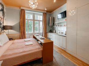 a bedroom with a bed with a desk and a kitchen at ELSO Muzeum apartments in Prague