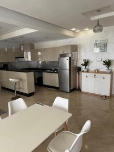 cocina grande con sillas blancas y nevera en Résidence hivernage Agadir Bay, beach, pool, proche Sofitel, en Agadir