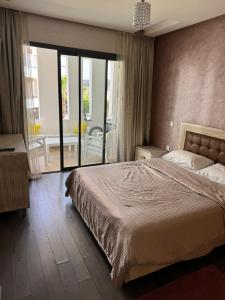 1 dormitorio con 1 cama grande y balcón en Résidence hivernage Agadir Bay, beach, pool, proche Sofitel, en Agadir
