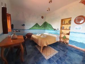 - une chambre avec un lit orné d'une peinture murale dans l'établissement Villino Miraglia, à Lingua