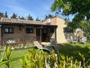 una casa con dos sillas de jardín en el patio en La Capparuccia, en Civitanova Marche