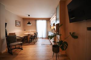 a living room with a table and chairs and a kitchen at Garni Appartements Arnika in Solda