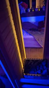 una puerta abierta a una escalera con luces azules en Refresh Club wellness, en Poruba