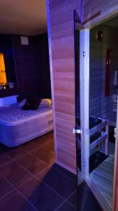 Habitación con cama y puerta de cristal en Refresh Club wellness, en Poruba