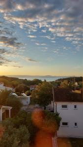 a view of a house with the ocean in the background at Apartman Premantura Rumora in Premantura