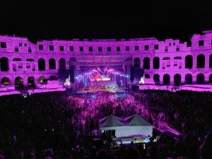 a crowd of people standing in front of a stage at night at Apartman Premantura Rumora in Premantura