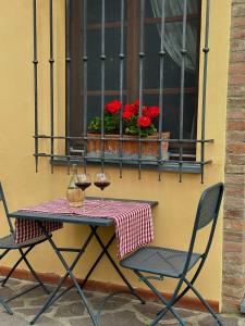 a table with two chairs and a window with flowers at Agriturismo Casa Alle Vacche in San Gimignano