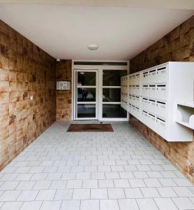 uma casa de banho com armários brancos e piso em azulejo em La cossonade em Menton