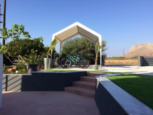 ein Fahrrad, das unter einem Pavillon mit einigen Treppen geparkt ist in der Unterkunft Poseidon Suites Hotel in Stavros