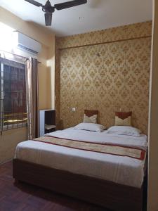 een slaapkamer met een groot bed met een muur bij Hotel Opera in Bharatpur