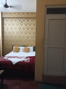 een slaapkamer met een bed en een deur naar een kamer bij Hotel Opera in Bharatpur