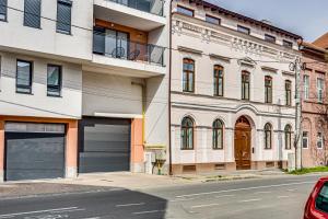 a building with two garage doors on a street at ARI Central Skyview Apartment in Arad