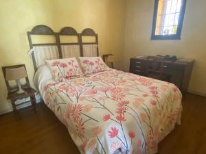 una camera con un letto e un piumone floreale di La Maison Vieille a Peillon