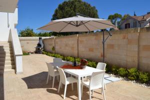 un tavolo e sedie con ombrellone su un patio di Villa Serena a Bagnolo del Salento