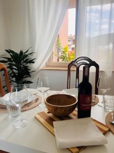 una bottiglia di vino seduta su un tavolo con bicchieri di Casa delle More a Siena