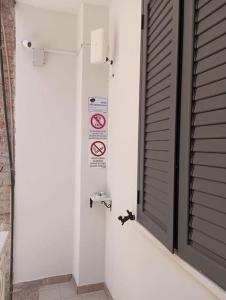 a bathroom with a door and a no smoking sign at Maria's guesthouse in Letojanni +21 photos