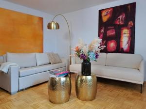 a living room with a couch and a vase with flowers at Art & Living I House and Rooms in Schoneck