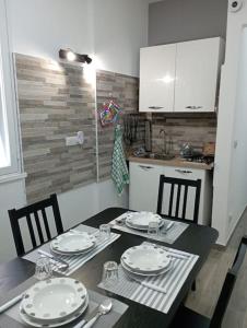 a kitchen with a table and chairs with plates andoverty at Maria's guesthouse in Letojanni