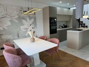 een keuken met een witte tafel en paarse stoelen bij Magnolia deluxe Apartment in Zagreb