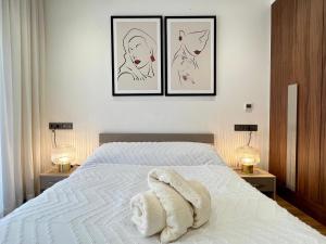 a white bed with three pictures on the wall at Dynasty Estate - Maarif residency in Casablanca