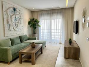 a living room with a green couch and a coffee table at Dynasty Estate - Maarif residency in Casablanca