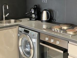 a kitchen with a washing machine and a sink at Dynasty Estate - Maarif residency in Casablanca