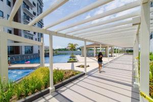 Punta EngañoにあるMactan Newtown Near Airport with POOL & BEACH ACCESSの建物横の歩道を歩く女